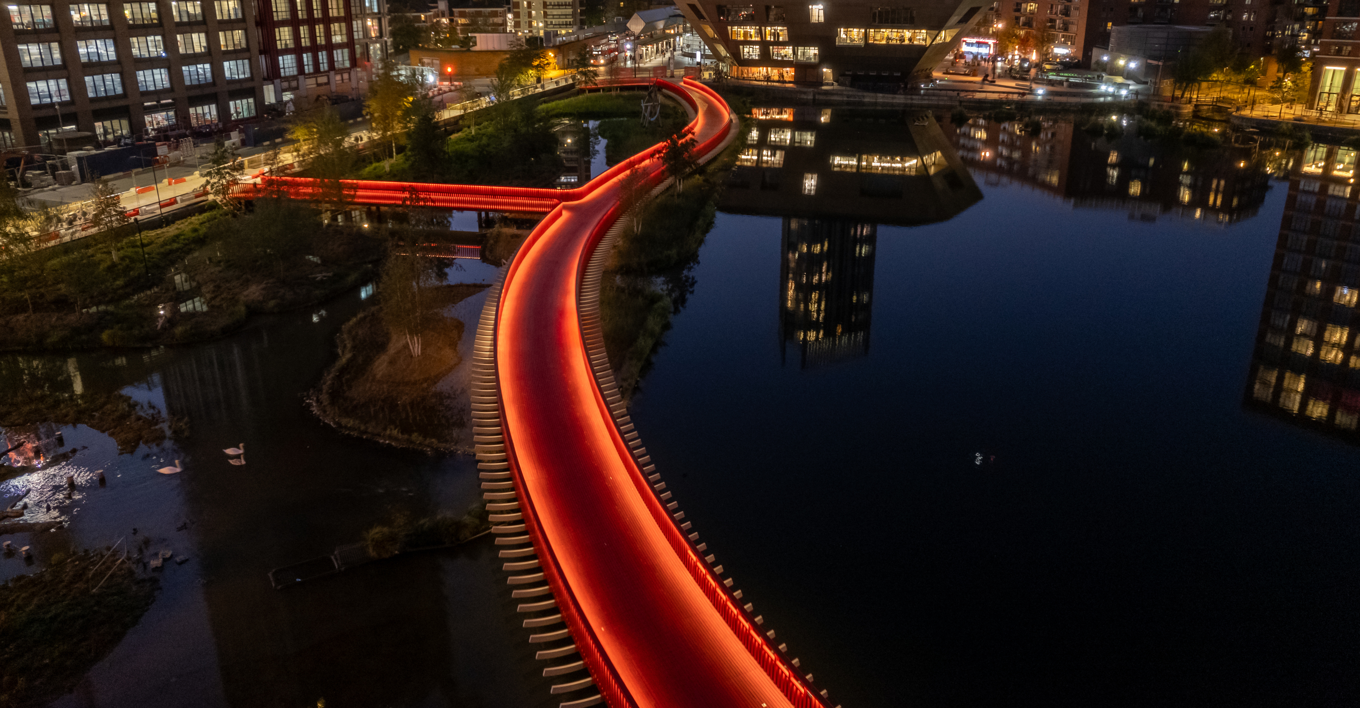 Canada Water’s boardwalk turns a simple curve into an evening landmark.